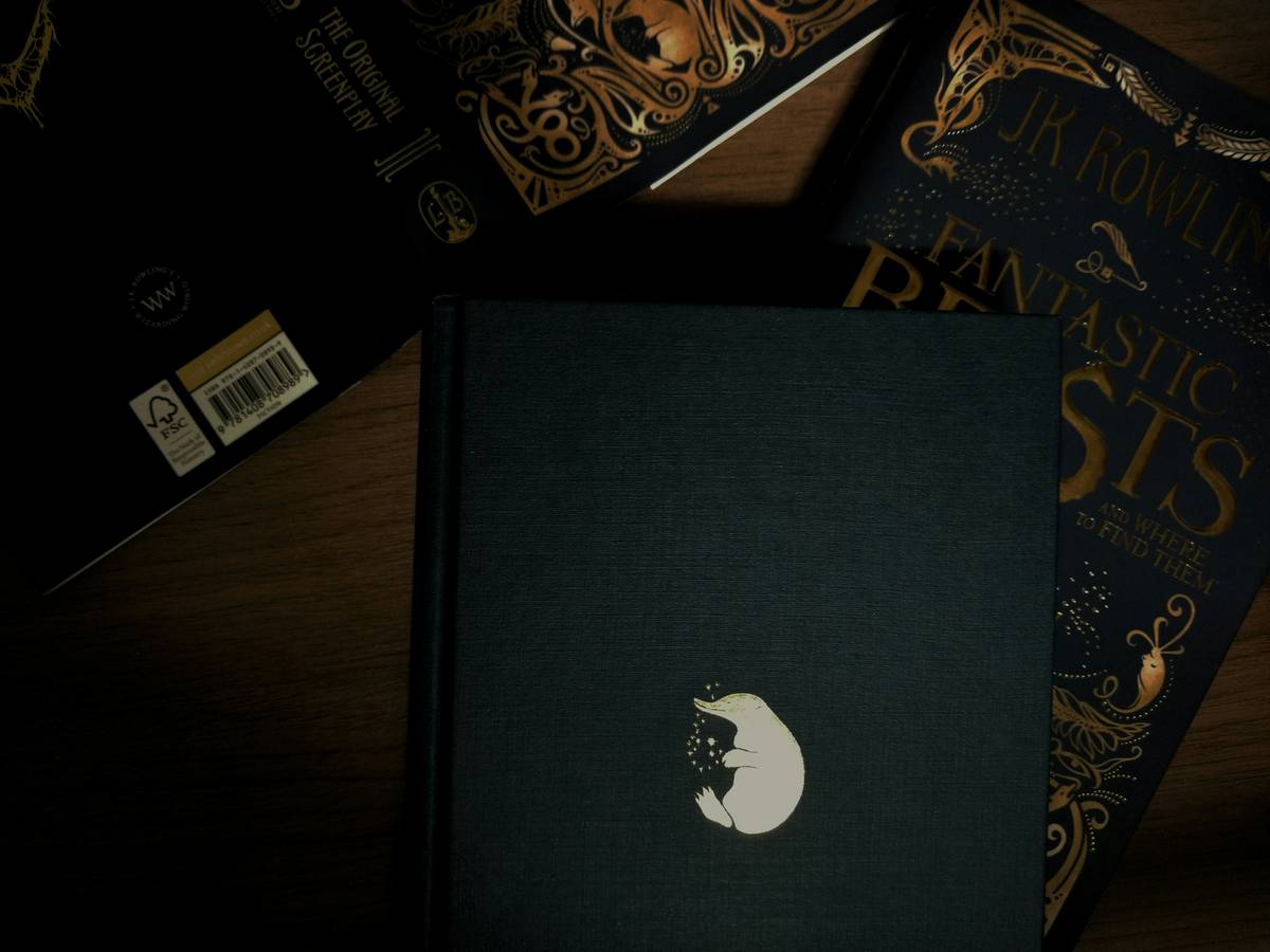 Stack of books with werewolf romance on a wooden desk beside gaming controller