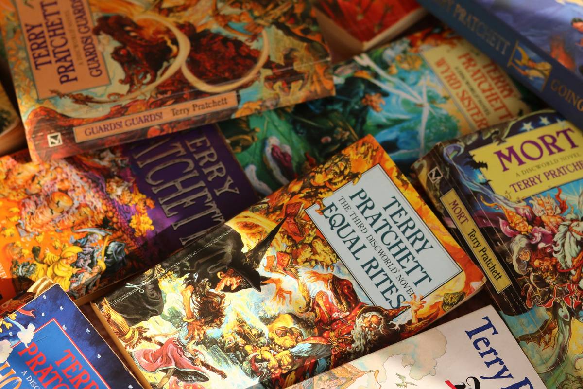 Stack of werewolf books for kids on a cozy reading nook shelf with moon-shaped bookmarks and a steaming mug nearby